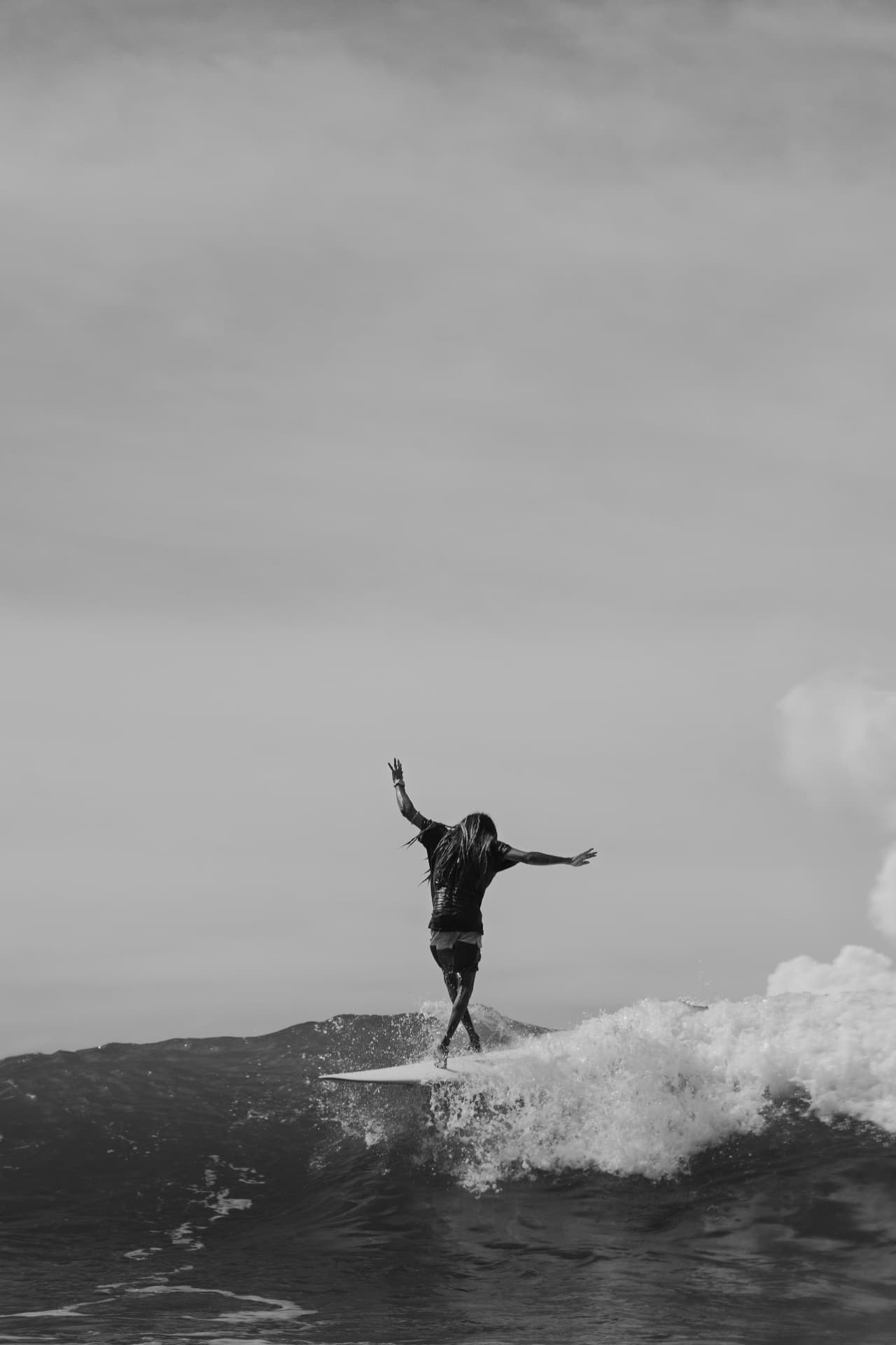 Longboarder walking the nose of a board in black and white