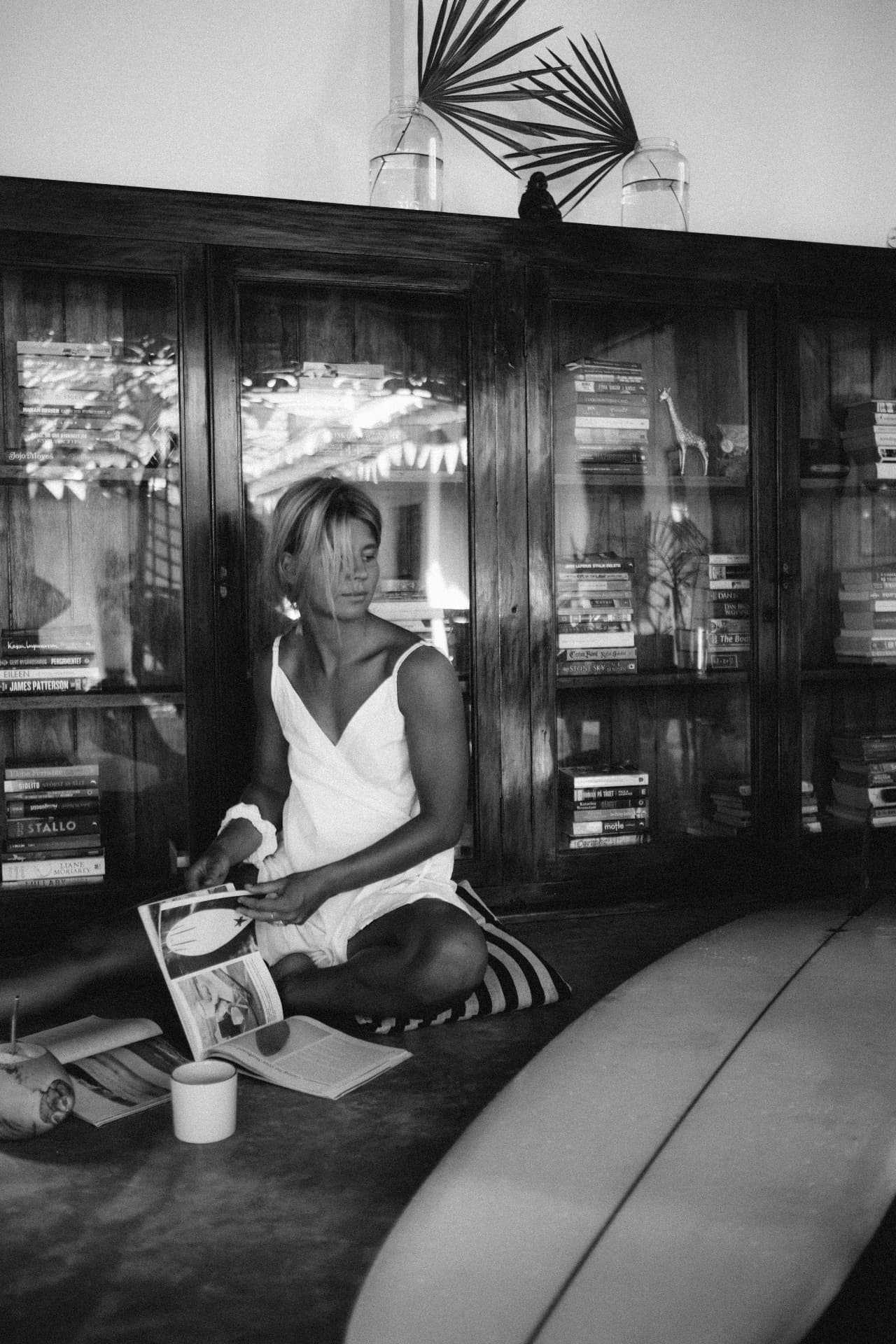 A guest reading magazines in front of a bookcase