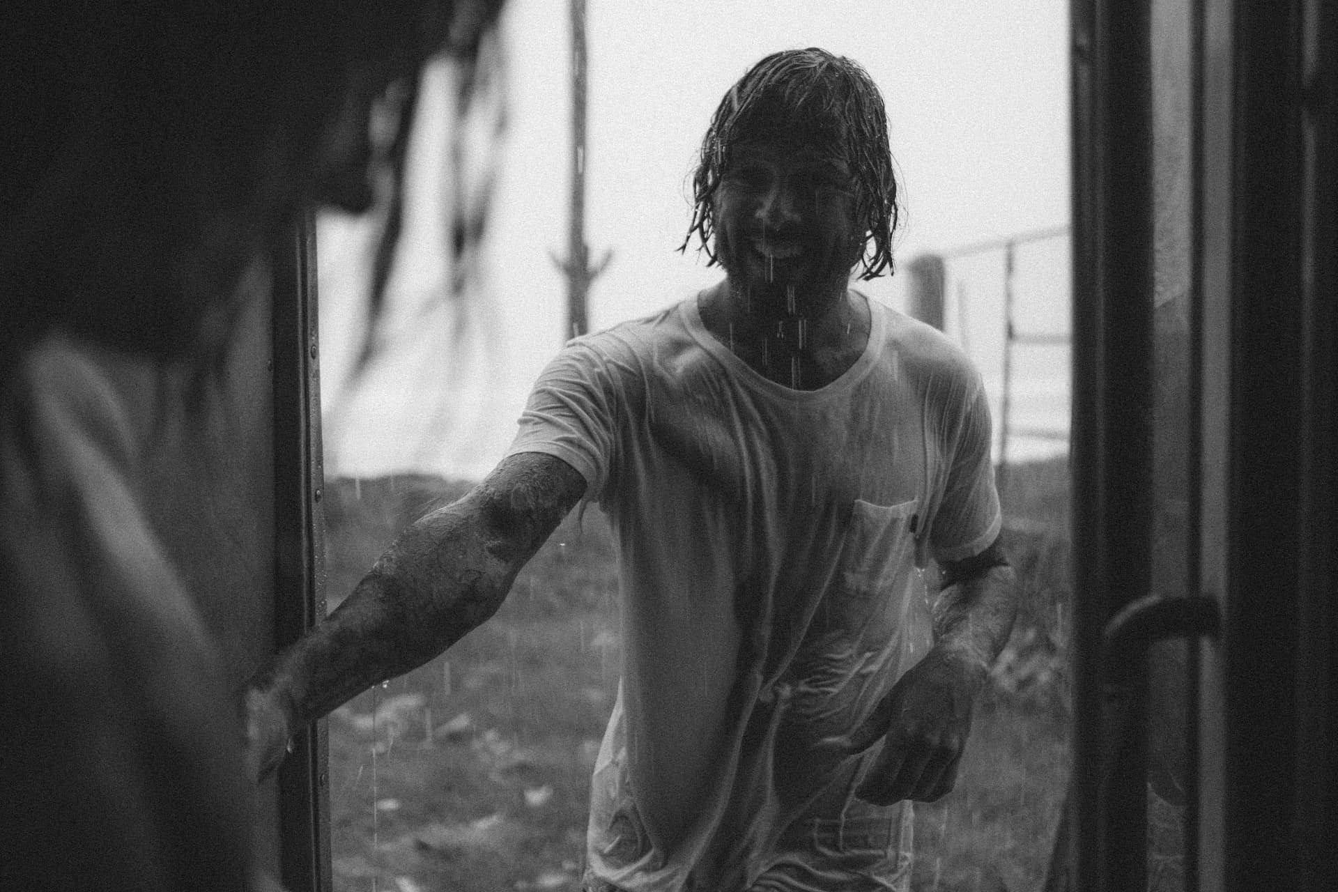 A laughing guest walking through tropical rain