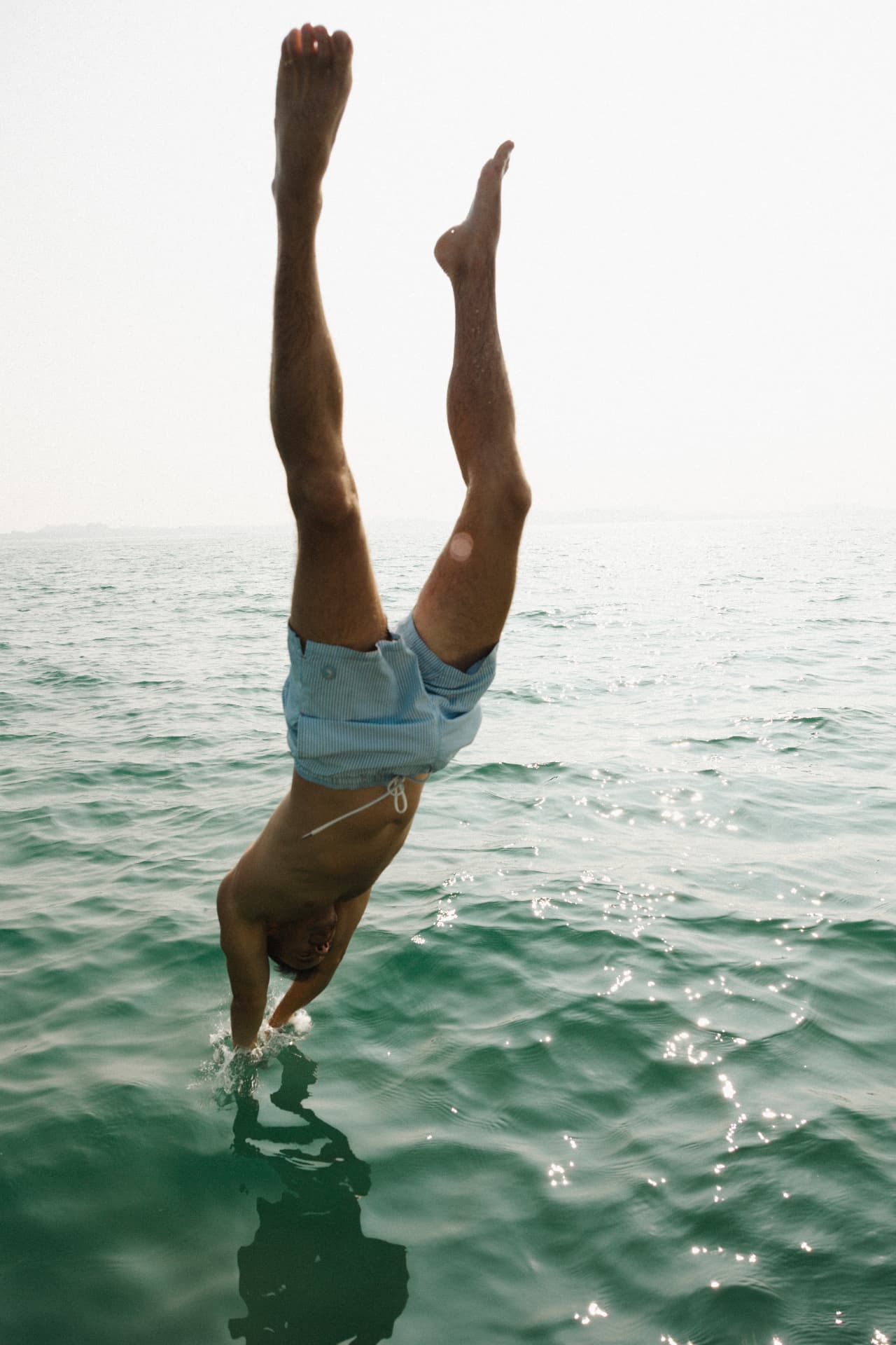 A guest diving headfirst into green ocean water