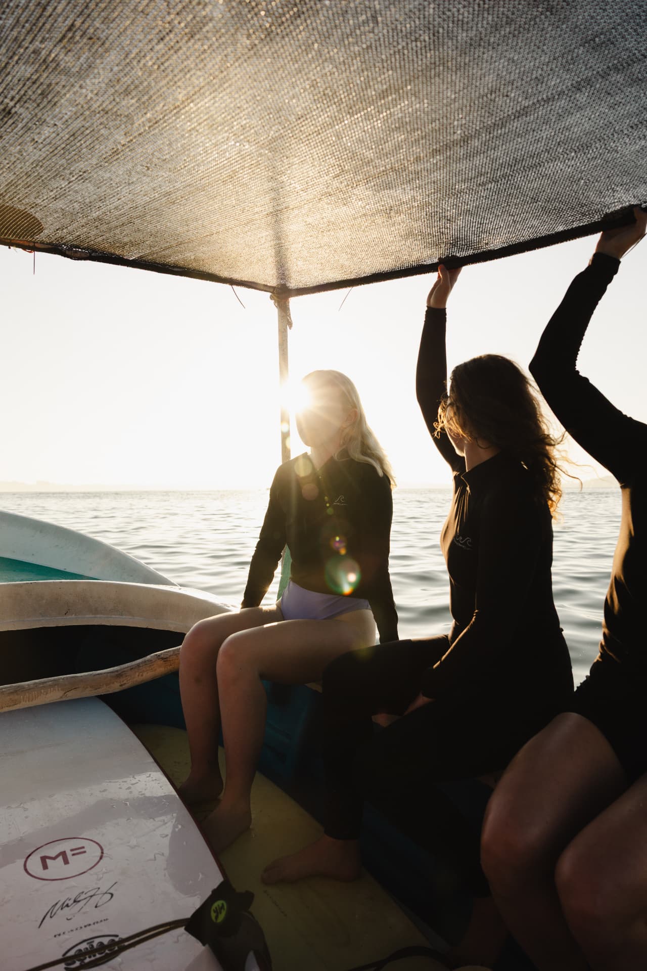 Guests on a boat at sunrise heading out to the surf