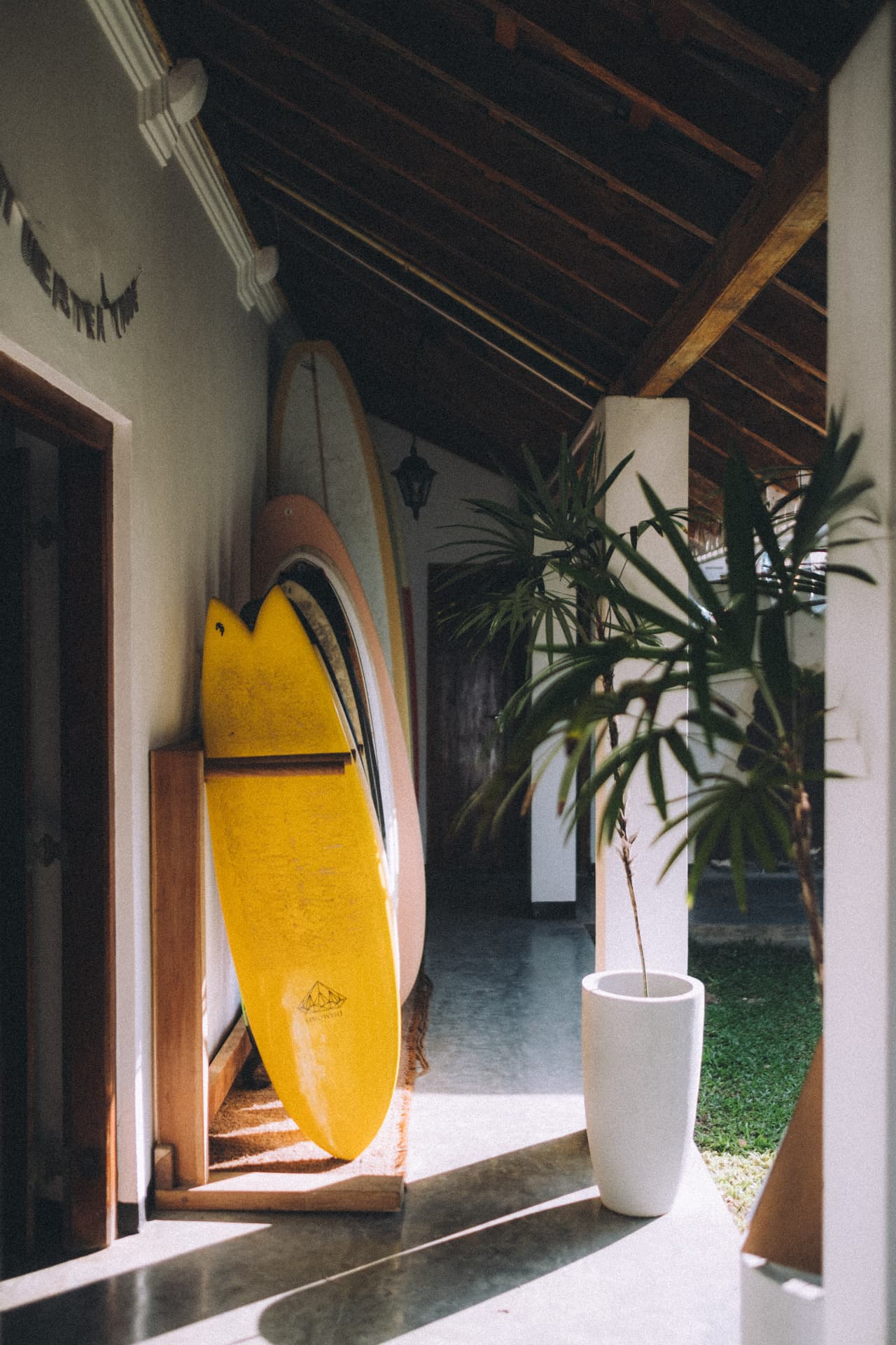 Colourful surfboards stacked in a rack along the villa corridor