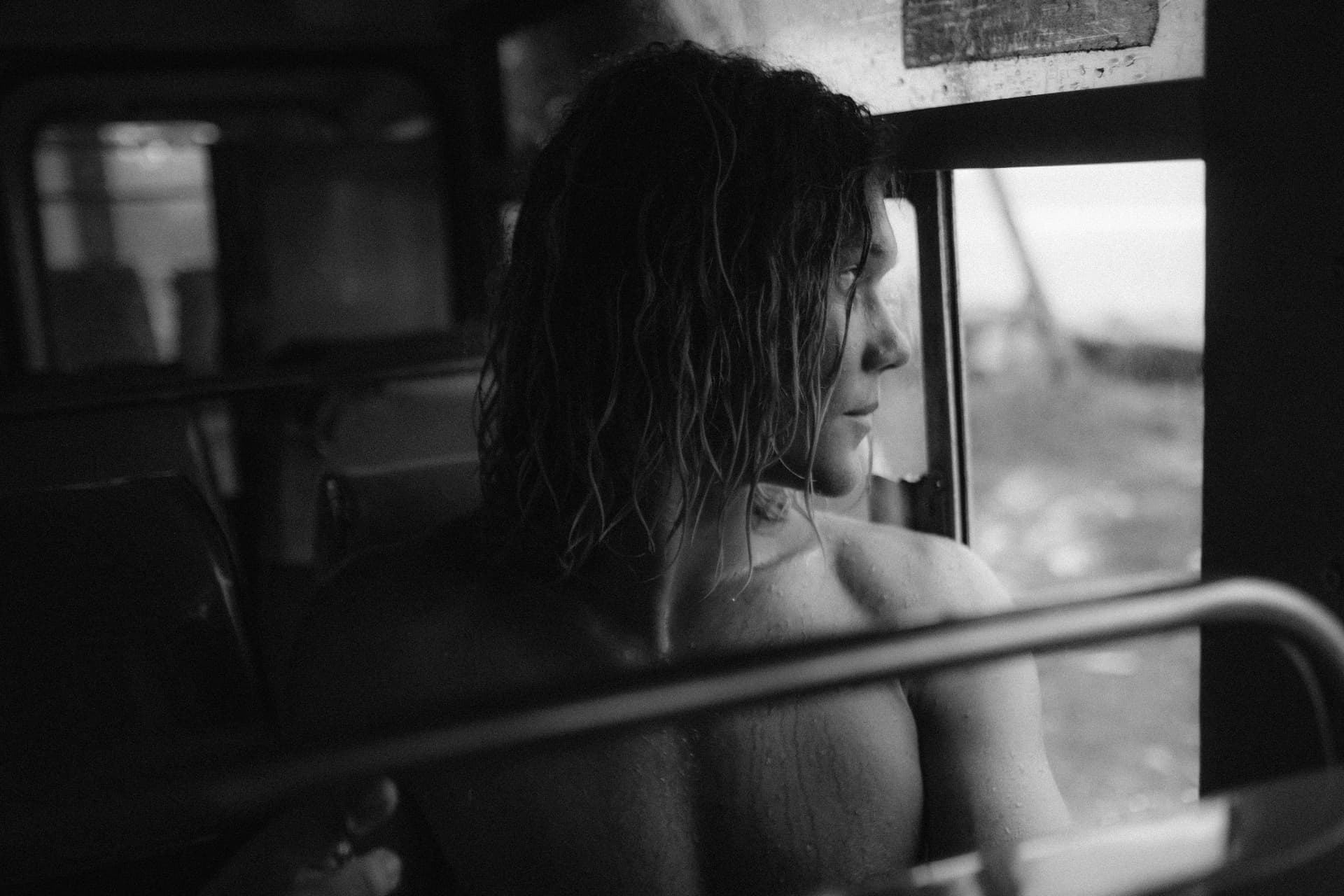 A guest gazing out a rain-streaked window