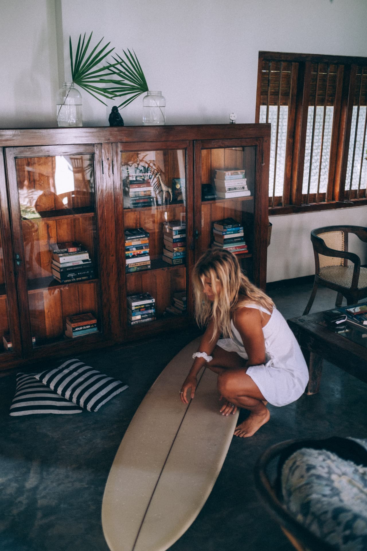 A guest waxing a longboard in the living room