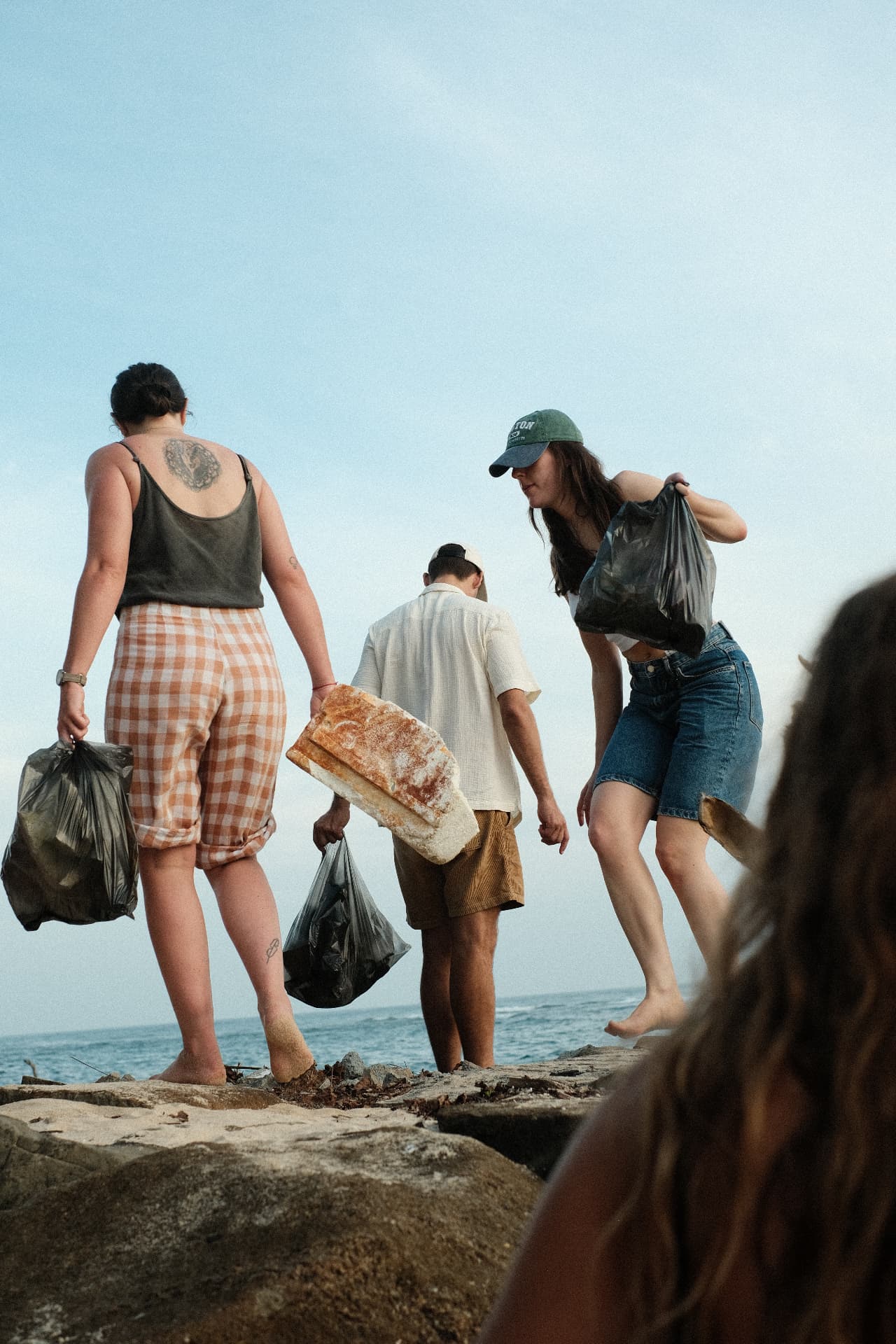 Guests carrying rubbish bags during a beach clean-up