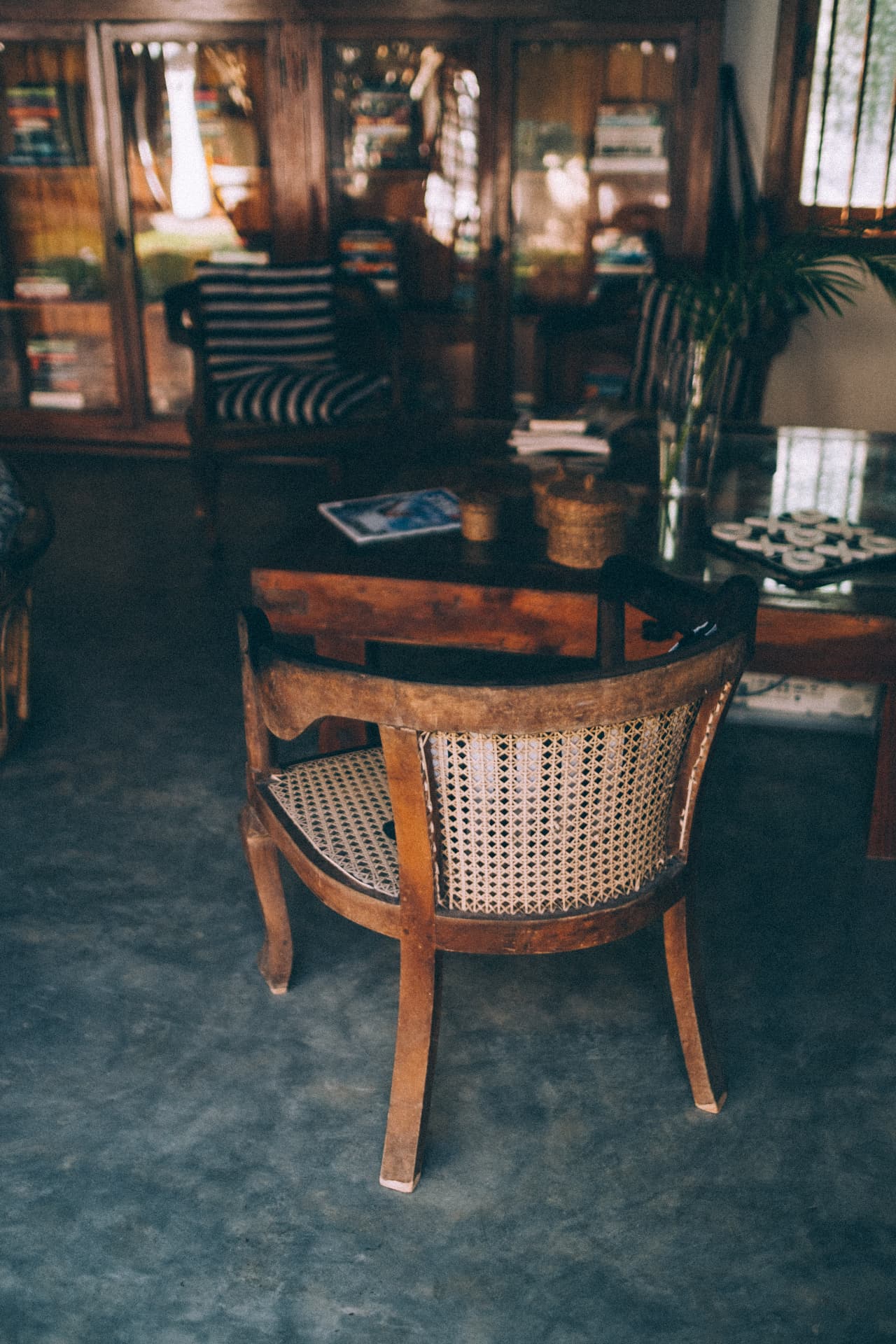 A cane chair beside the bookshelves in the main house