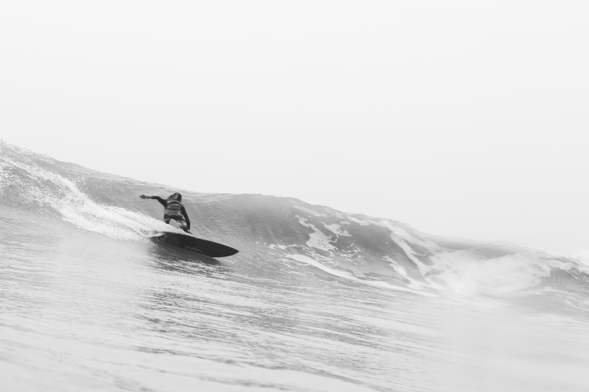 A surfer drawing a clean line in black and white