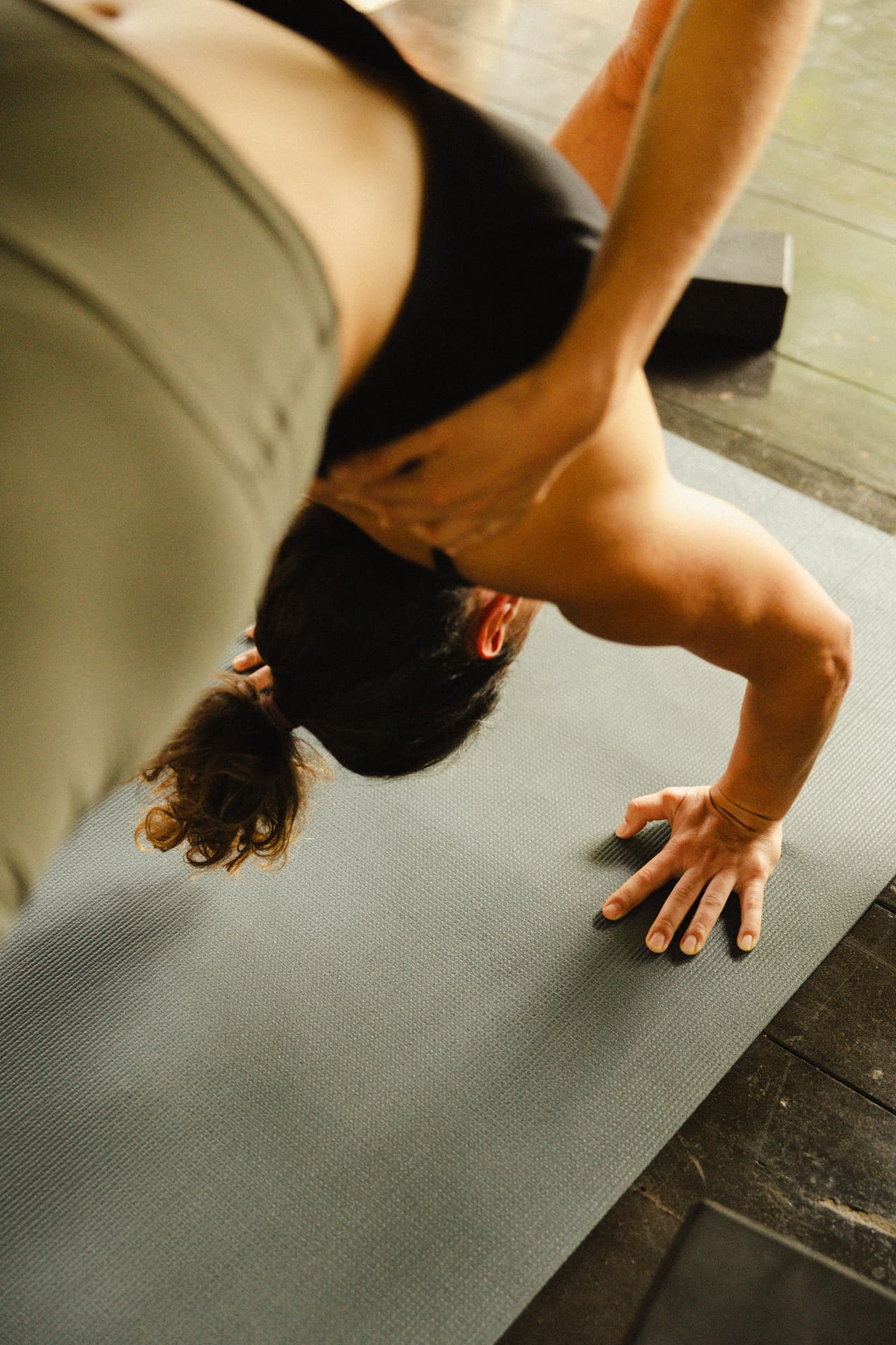 A guest balancing in a headstand on a mat in the shala