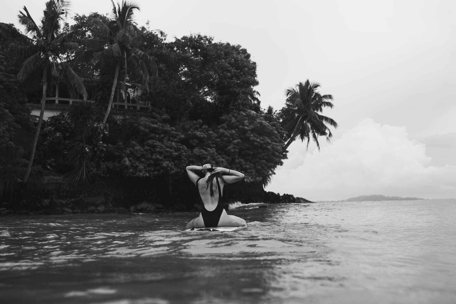 A guest sitting on a board in calm water
