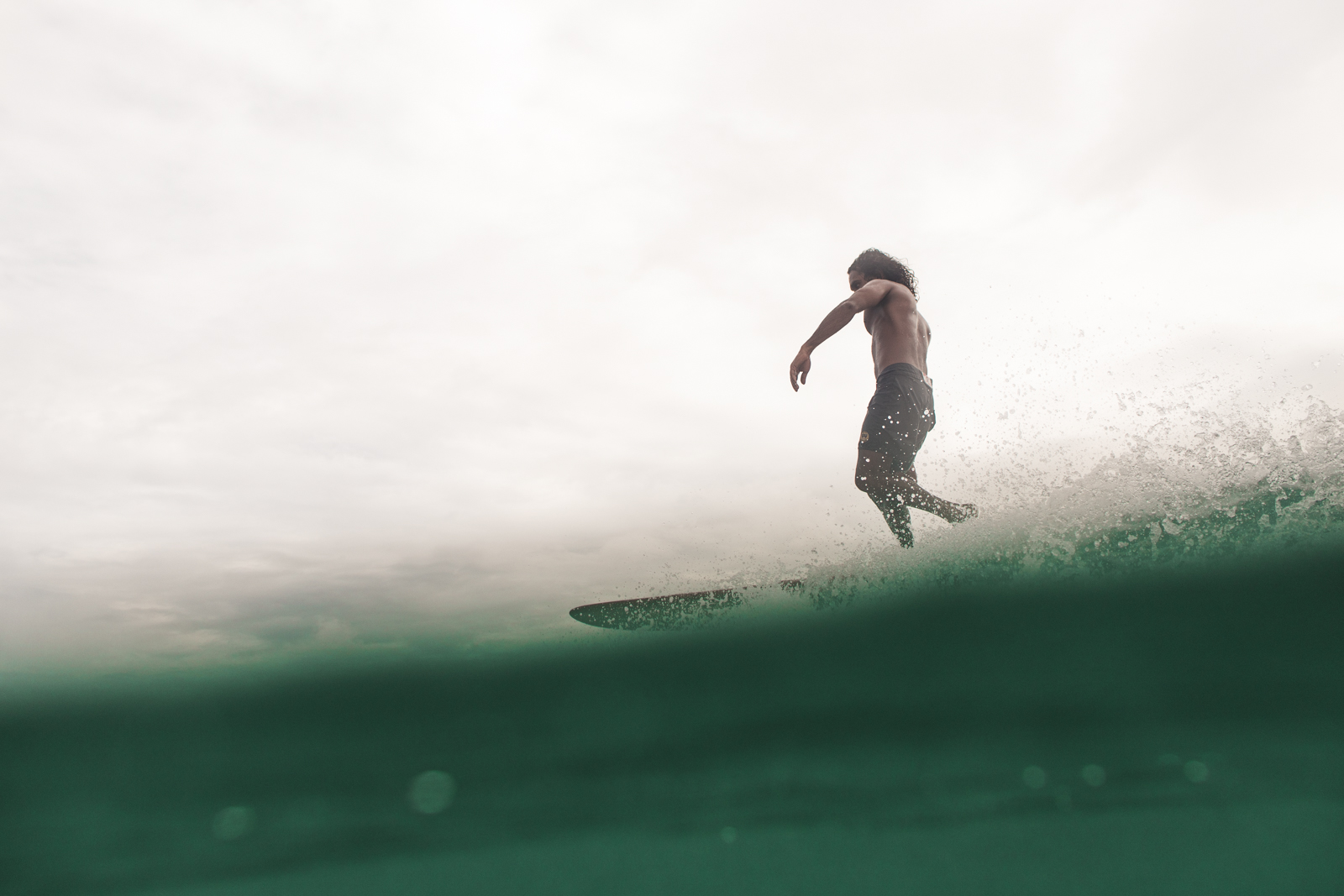 A surfer trimming on a green wave