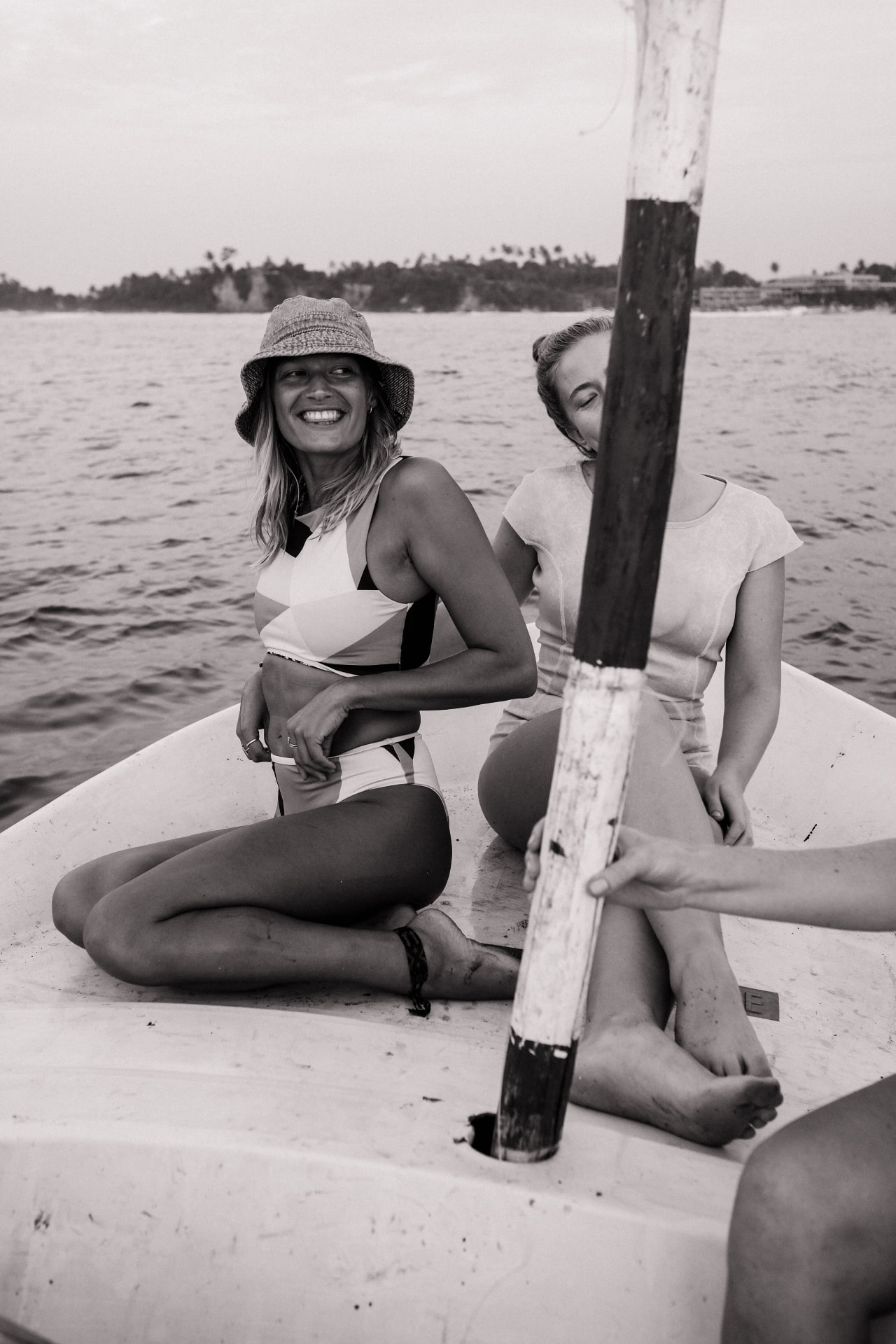 Two friends laughing together on a boat in black and white