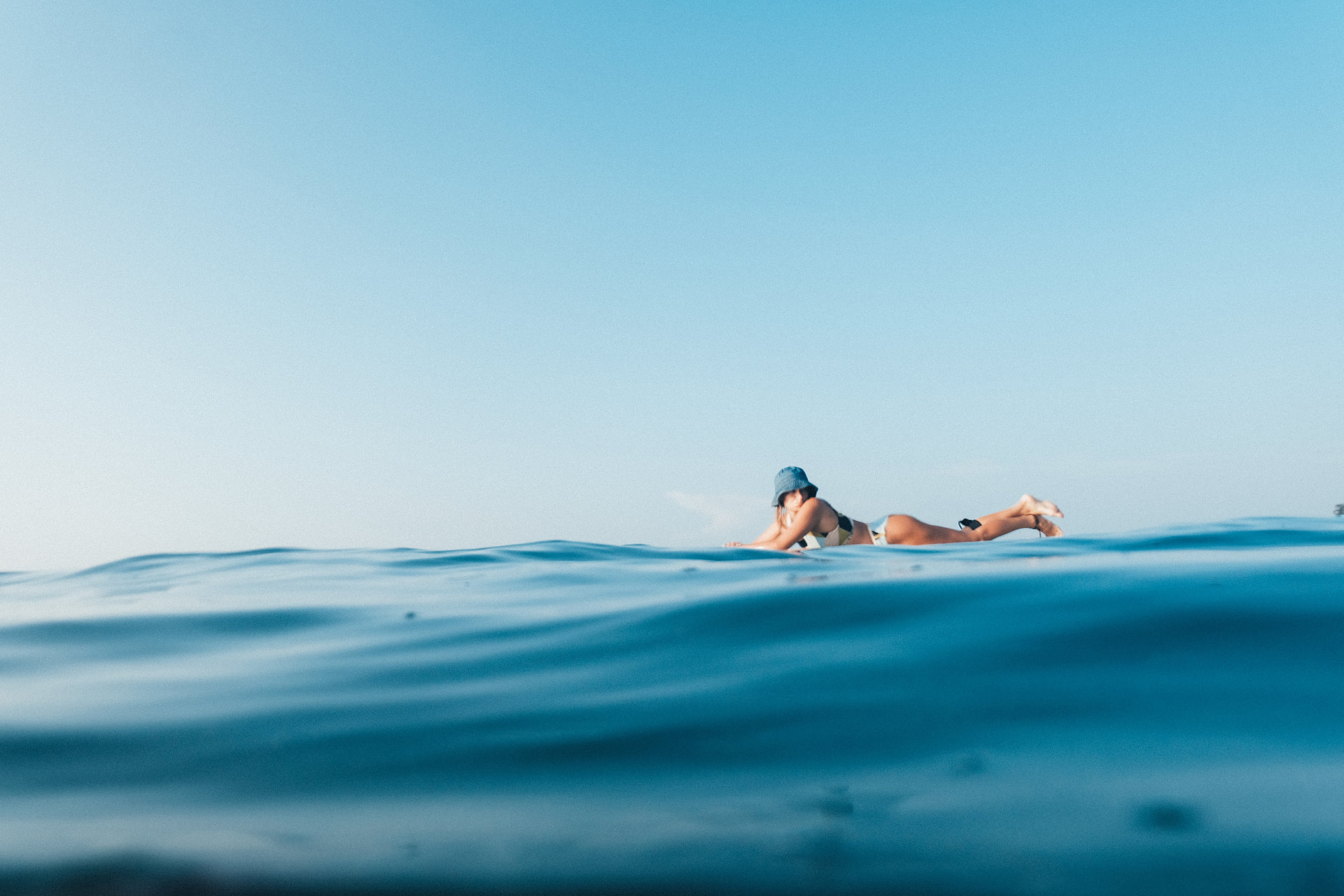 Surfer waiting alone in the lineup on deep blue water off the Sri Lankan coast