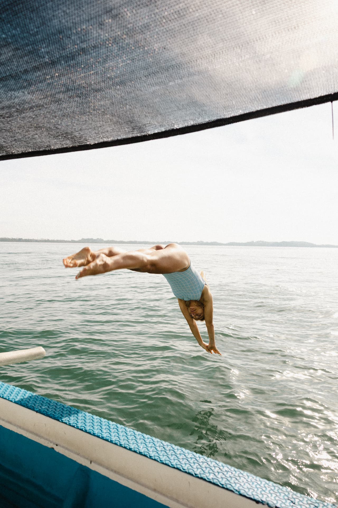 A guest diving off the boat into clear water
