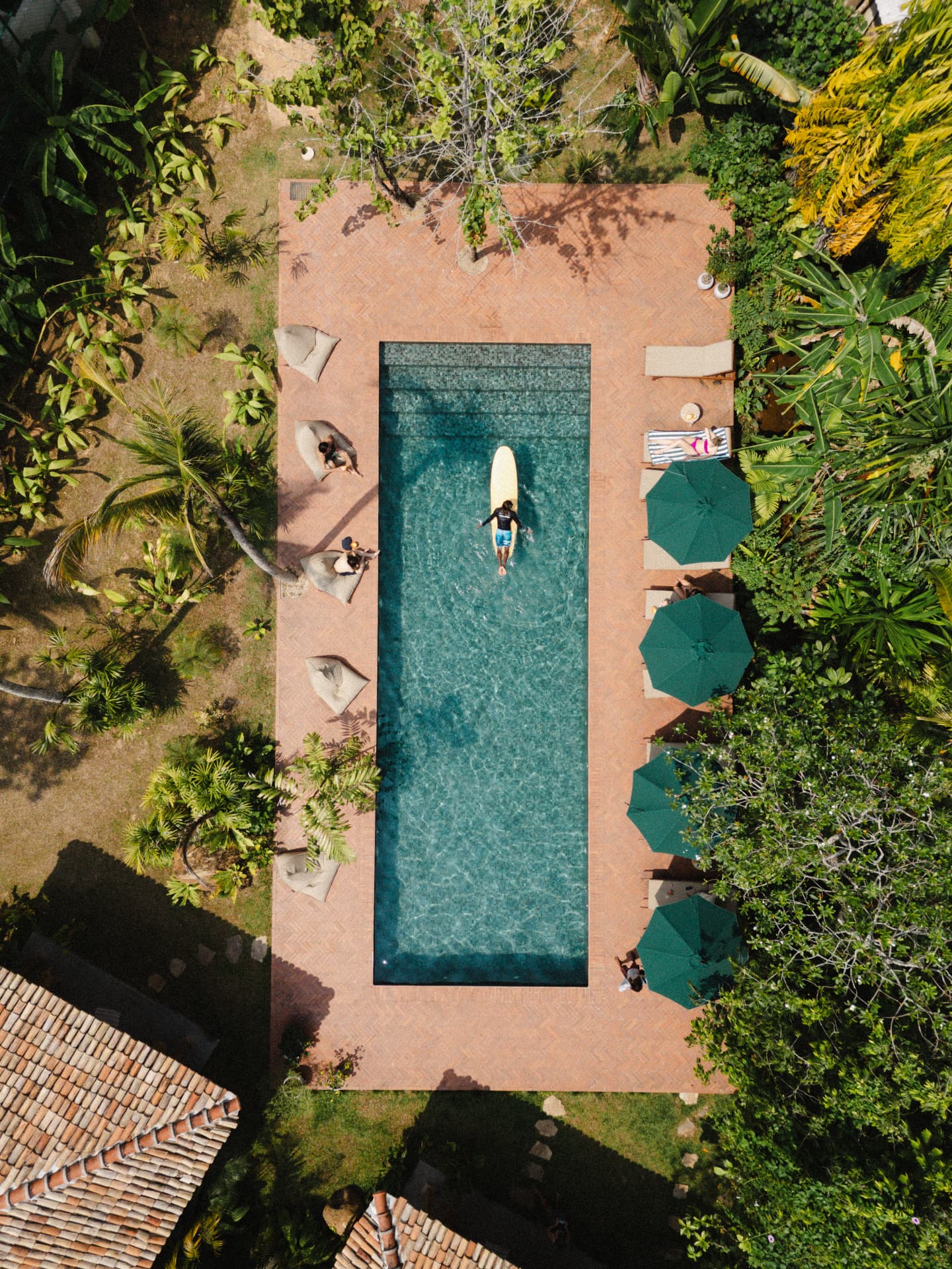 Overhead view of a guest paddling a longboard in the retreat pool